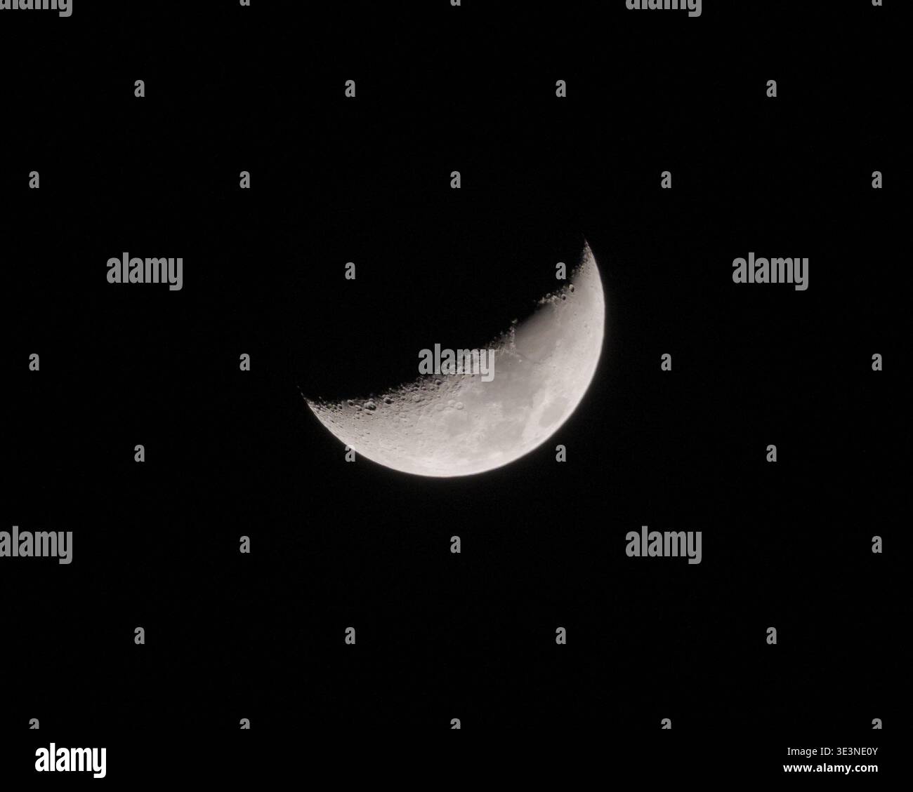 Crescent Moon risplende brillantemente in un cielo notturno buio rivelando la sua texture dettagliata della superficie Foto Stock