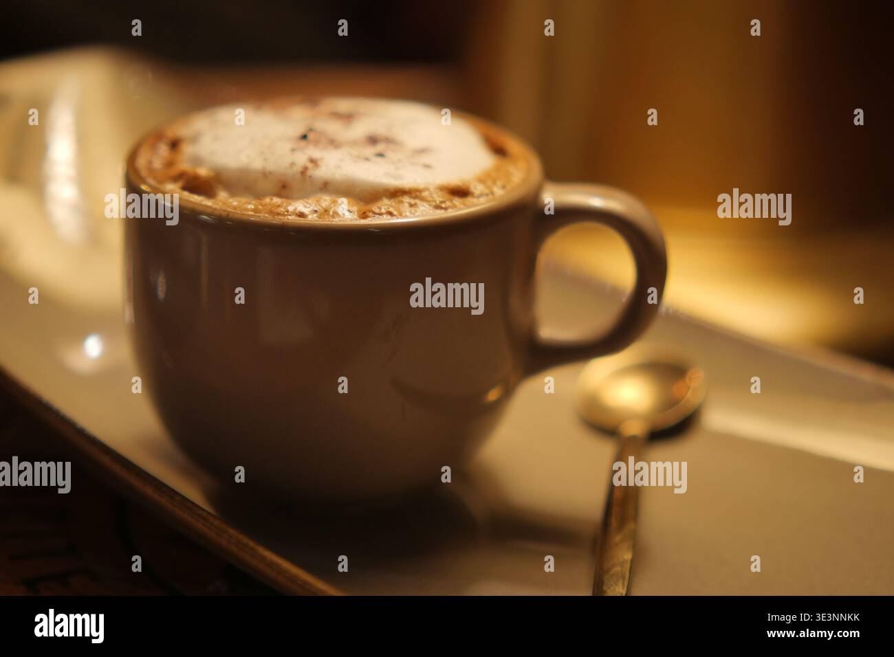 Caffè caldo in tazza bianca su un piattino con cucchiaio Foto Stock