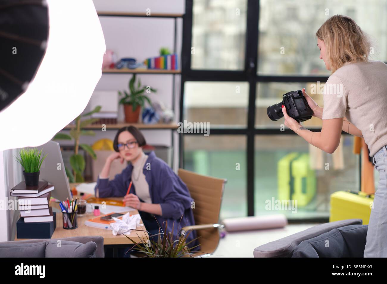 La sessione creativa cattura un artista concentrato in uno studio vivace pieno di ispirazione e colori brillanti durante un pomeriggio di sole Foto Stock