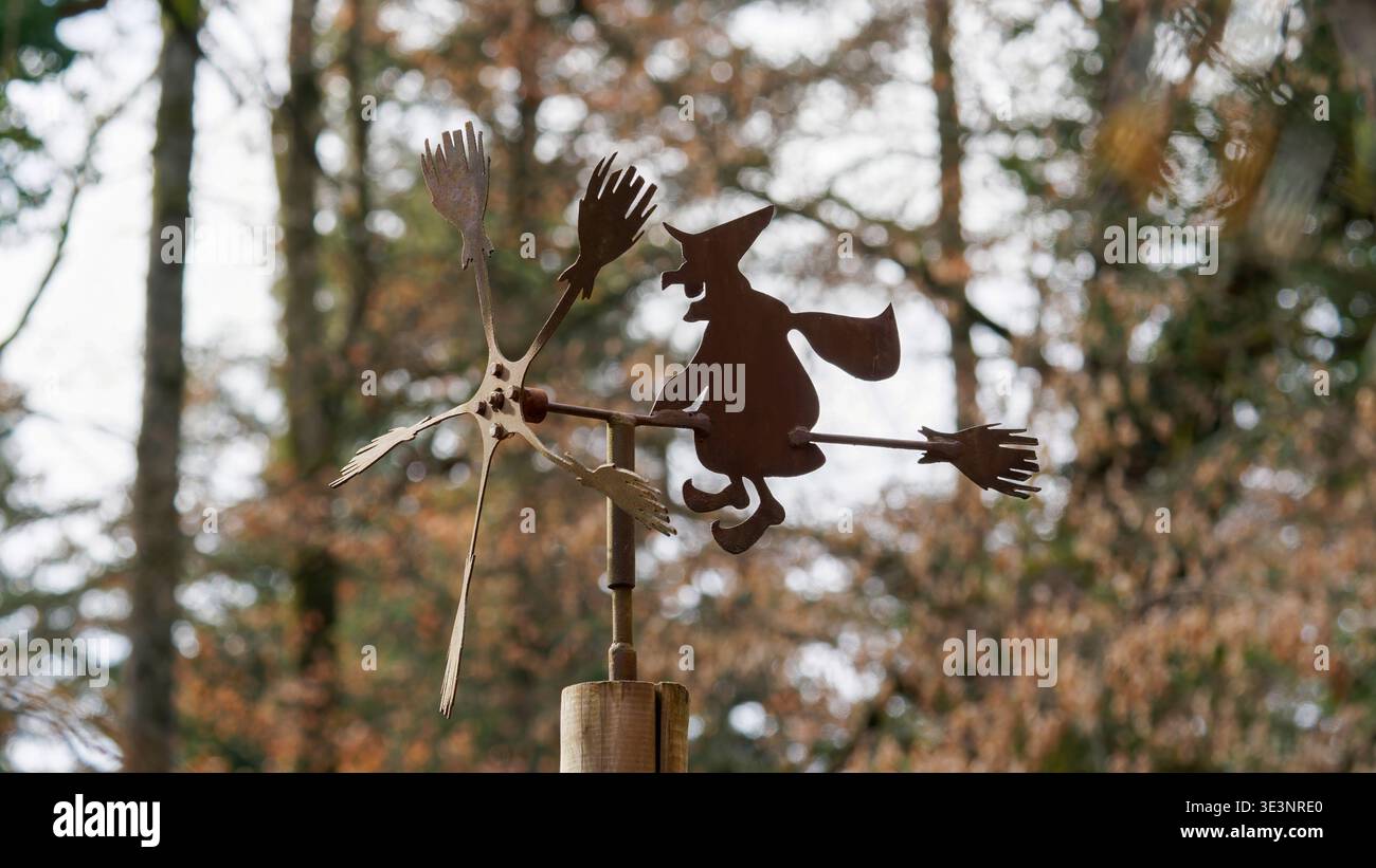 Stravagante Flying Witch Weathervane: Giocosa silhouette in metallo che gira nella foresta autunnale Foto Stock