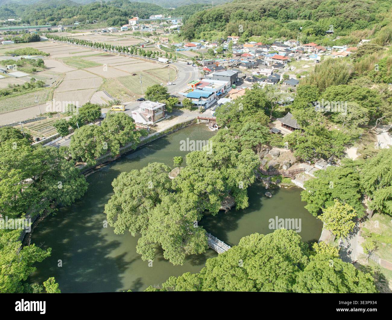 Vista aerea del Padiglione Mujinjeong ad Haman, Corea del Sud. Mostra un'architettura tradizionale circondata da un tranquillo laghetto, alberi verdi e un ponte. Foto Stock