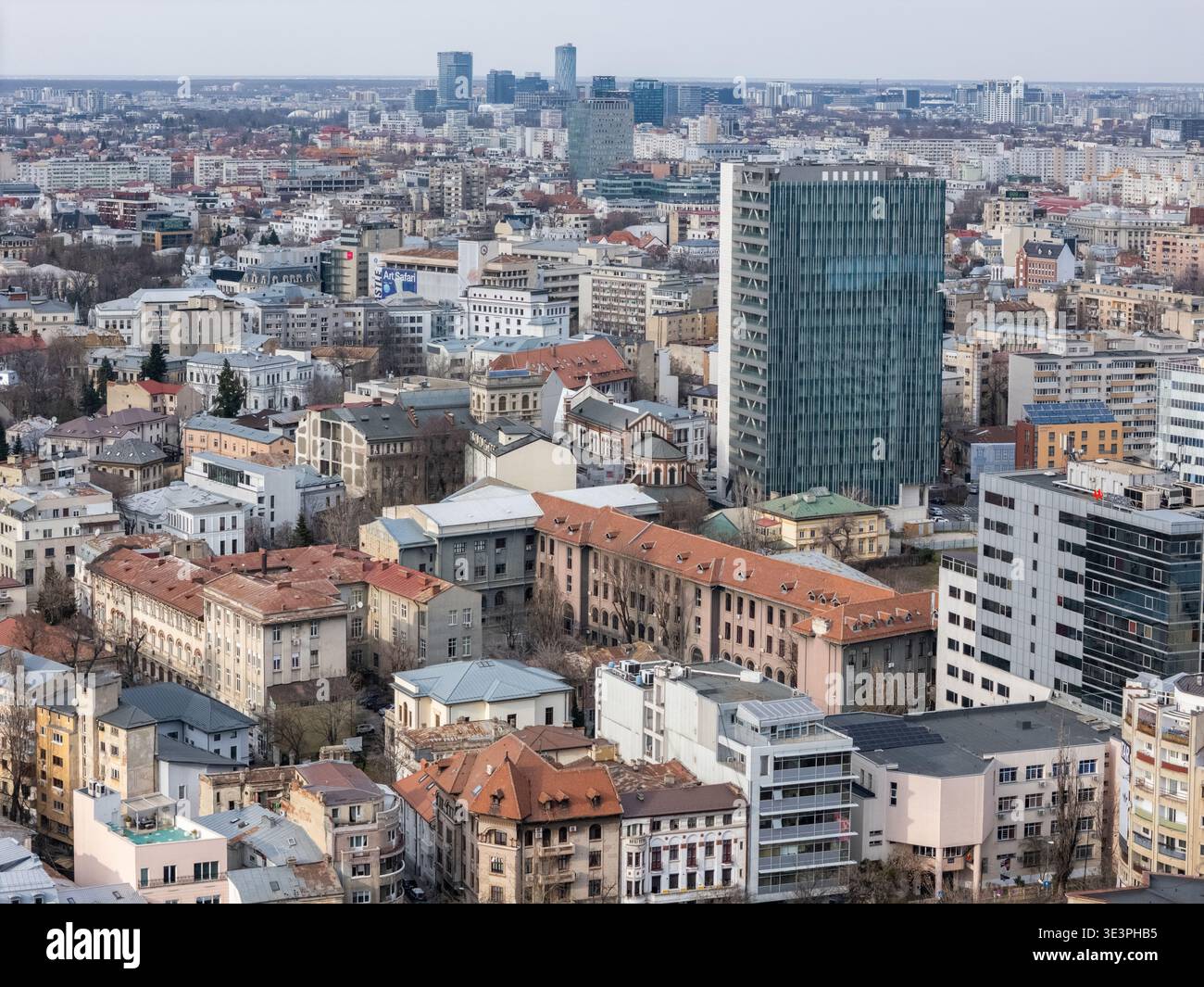 Vista aerea dello skyline, con il suo mix di moderne torri di vetro ed edifici storici sotto un cielo pallido, Bucarest, Bucarest, Romania. Foto Stock