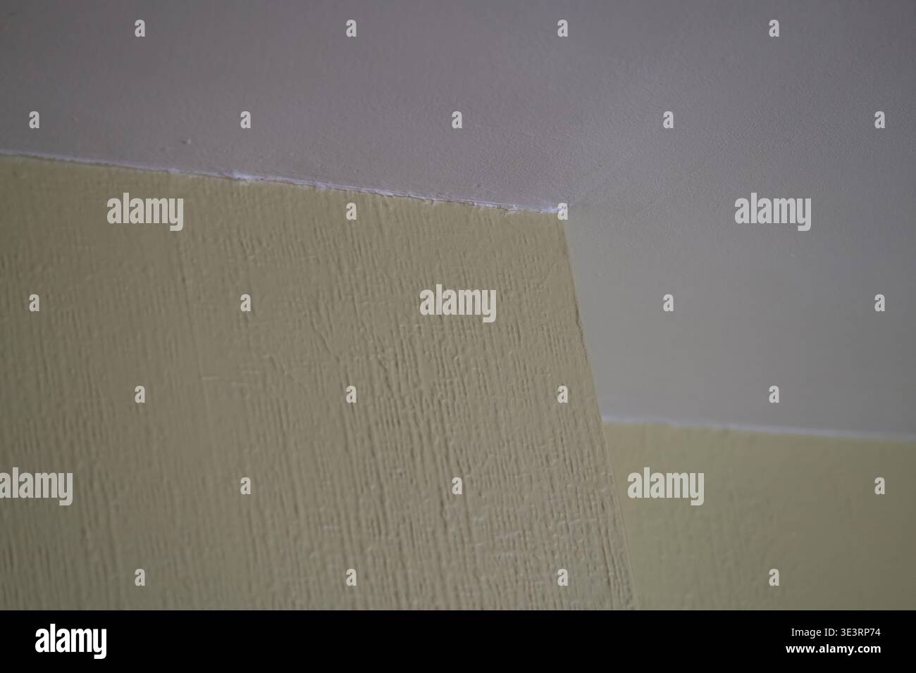 Primo piano della vernice incrinata nell'angolo della parete con danni visibili alla superficie e finitura irregolare. Concetto di scarsa ristrutturazione, invecchiamento degli interni e manutenzione iss Foto Stock