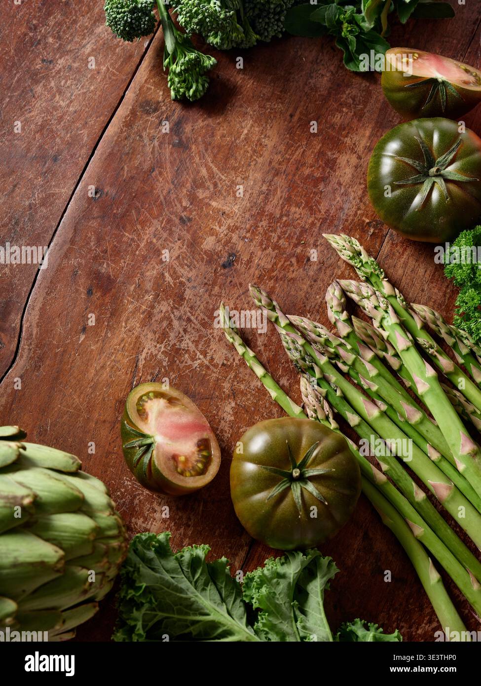 Le verdure fresche sono ordinate su un rustico tavolo di legno. Questo ambiente mette in mostra gli ingredienti per un pasto vegano. Ogni elemento evidenzia la nutrizione e. Foto Stock