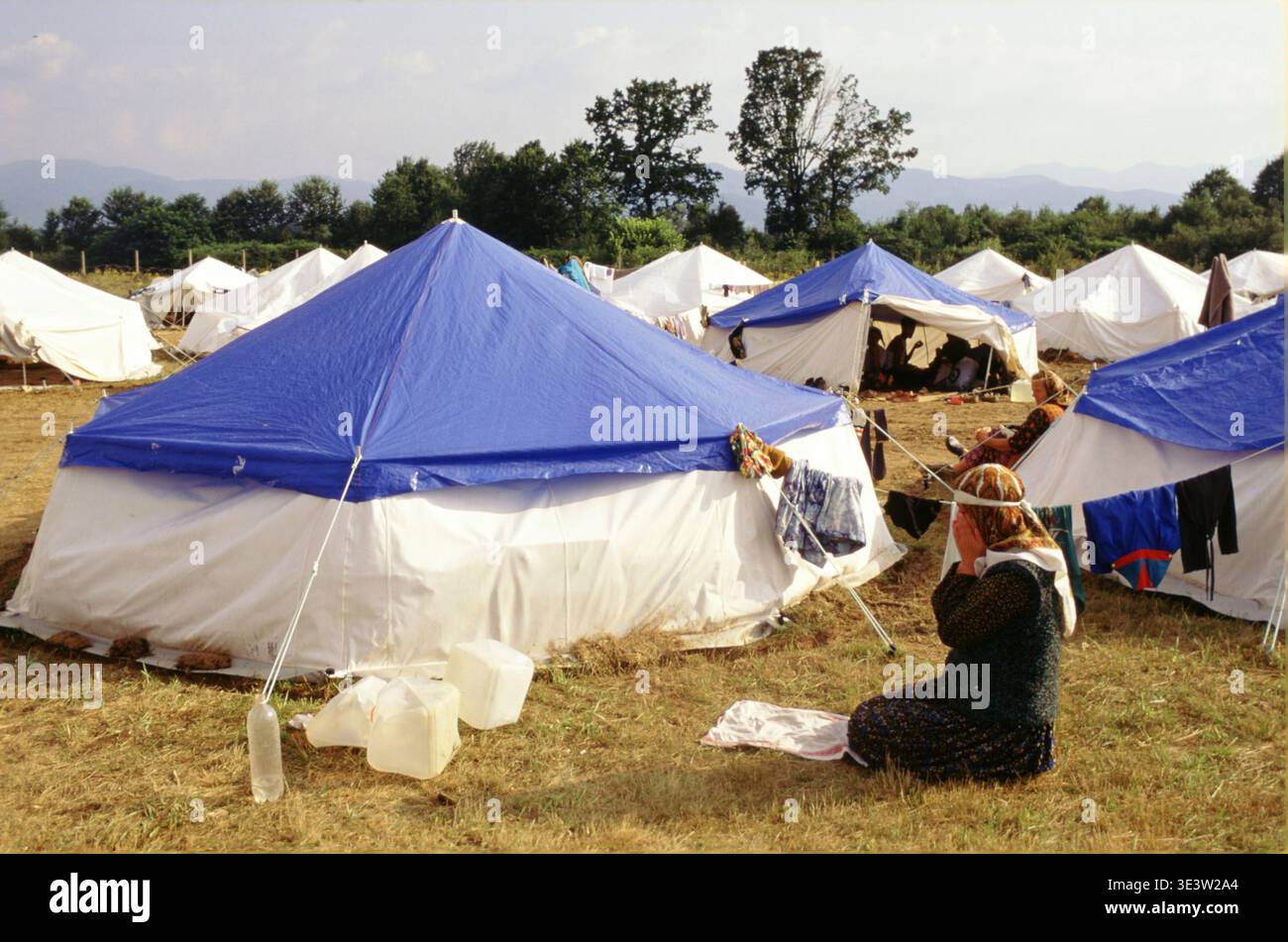 Tuzla, Bosnia, luglio 1995. In un centro di accoglienza per rifugiati da Shrebrenica alla base aerea di Tuzla, presso Woman prega. Foto Stock