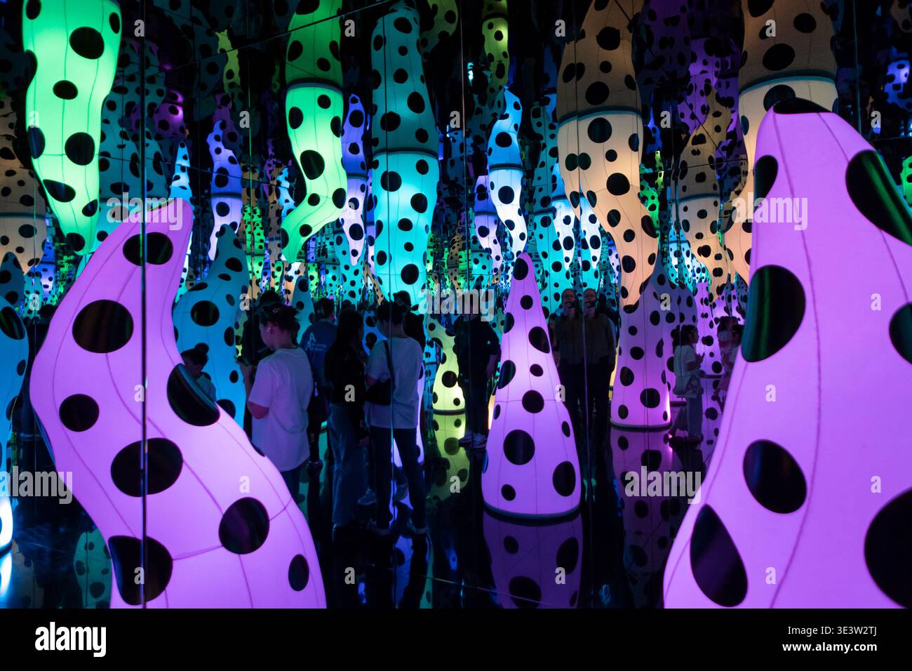 Yayoi Kusama Love chiama sculture a pois viola con i visitatori tra gli specchi di Almaty Foto Stock