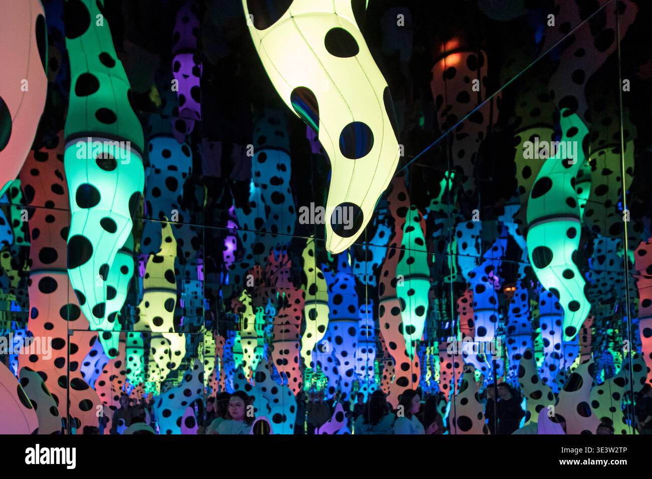 Yayoi Kusama Love chiama scultura appesa di giallo sopra i riflessi colorati degli specchi ad Almaty Foto Stock