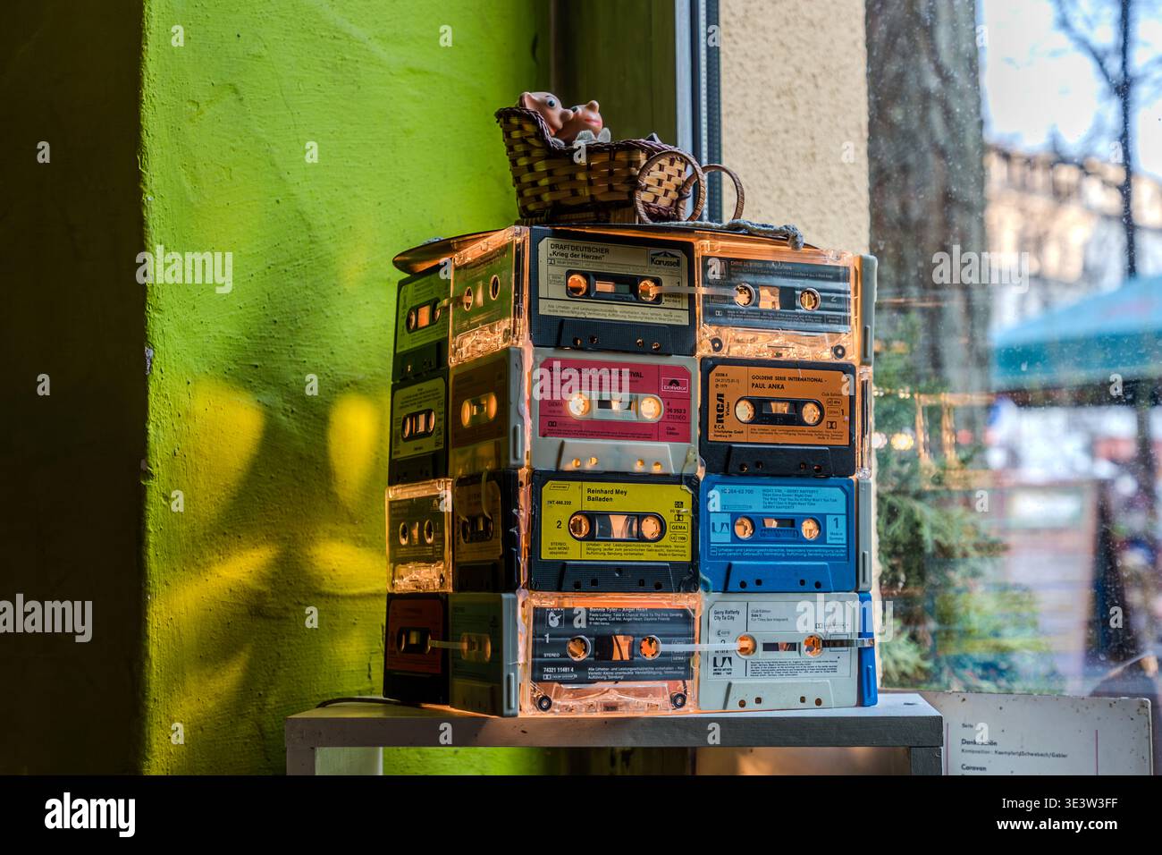 Una lampada da tavolo realizzata con cassette sovrapposte degli anni '1970 e '1980, che funge da nostalgico ricordo della RDT, esposta in una finestra del ristorante Kollektiv Leipzig; le maniche a cassetta presentano Reinhard Mey e altri artisti. Lipsia, Sassonia, Germania Foto Stock
