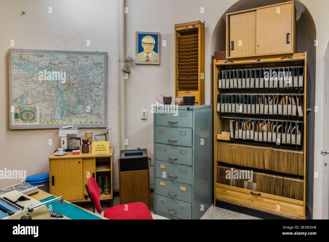 Un ufficio ricostruito di un ufficiale della Stasi presso il Museo del Runden Ecke di Lipsia: Sul muro, una mappa di Lipsia e un ritratto di Erich Honecker, accanto agli armadietti originali in acciaio e un sistema di indici di carte completamente rifornito dell'era della RDT. Lipsia, Sassonia, Germania Foto Stock