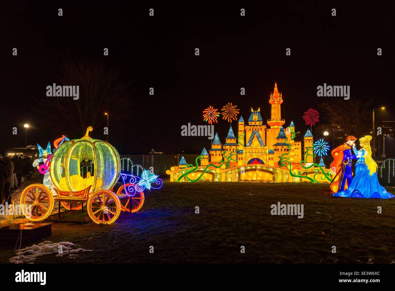 Magica carrozza per zucca, castello da favola e personaggi illuminano un festival notturno delle lanterne Foto Stock