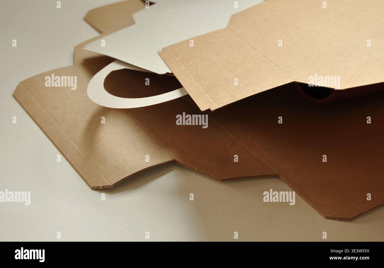Scatole in cartone marrone, aperte, a strati. Sfondo artistico astratto. Concetto di imballaggio sostenibile, modello di imballaggio, industria del legno e della carta Foto Stock