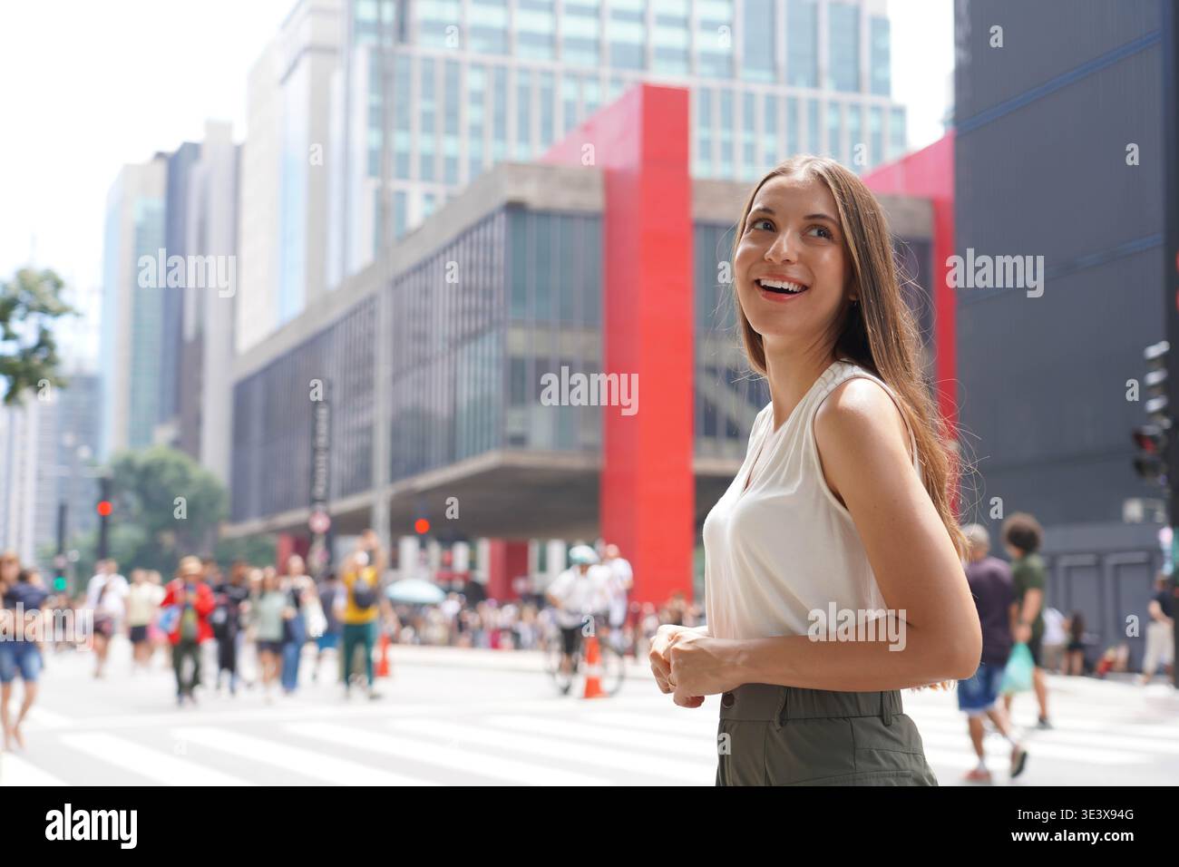 Felice giovane donna sorridente di fronte al MASP Museum in Paulista Avenue, San Paolo, Brasile Foto Stock