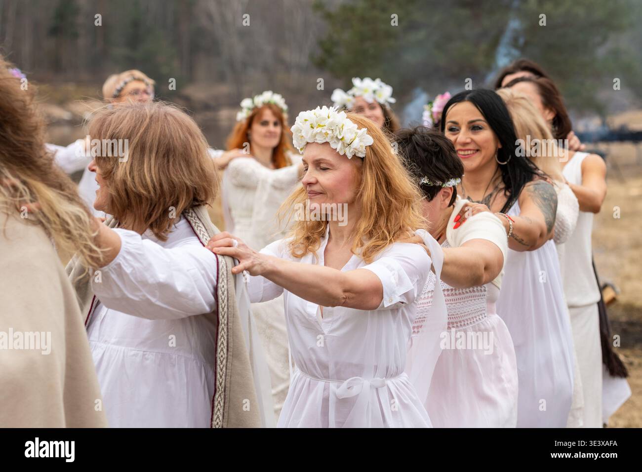 Donne in abiti bianchi e ghirlande che celebrano l'equinozio primaverile a Kernave, la capitale medievale del Granducato di Lituania, patrimonio mondiale dell'UNESCO Foto Stock