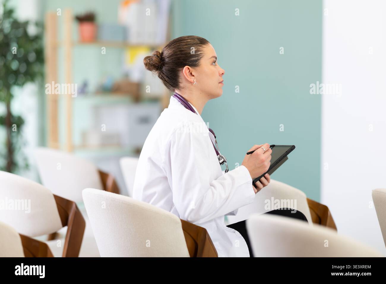 Studentessa di medicina che ascolta la lezione in classe con il tablet Foto Stock