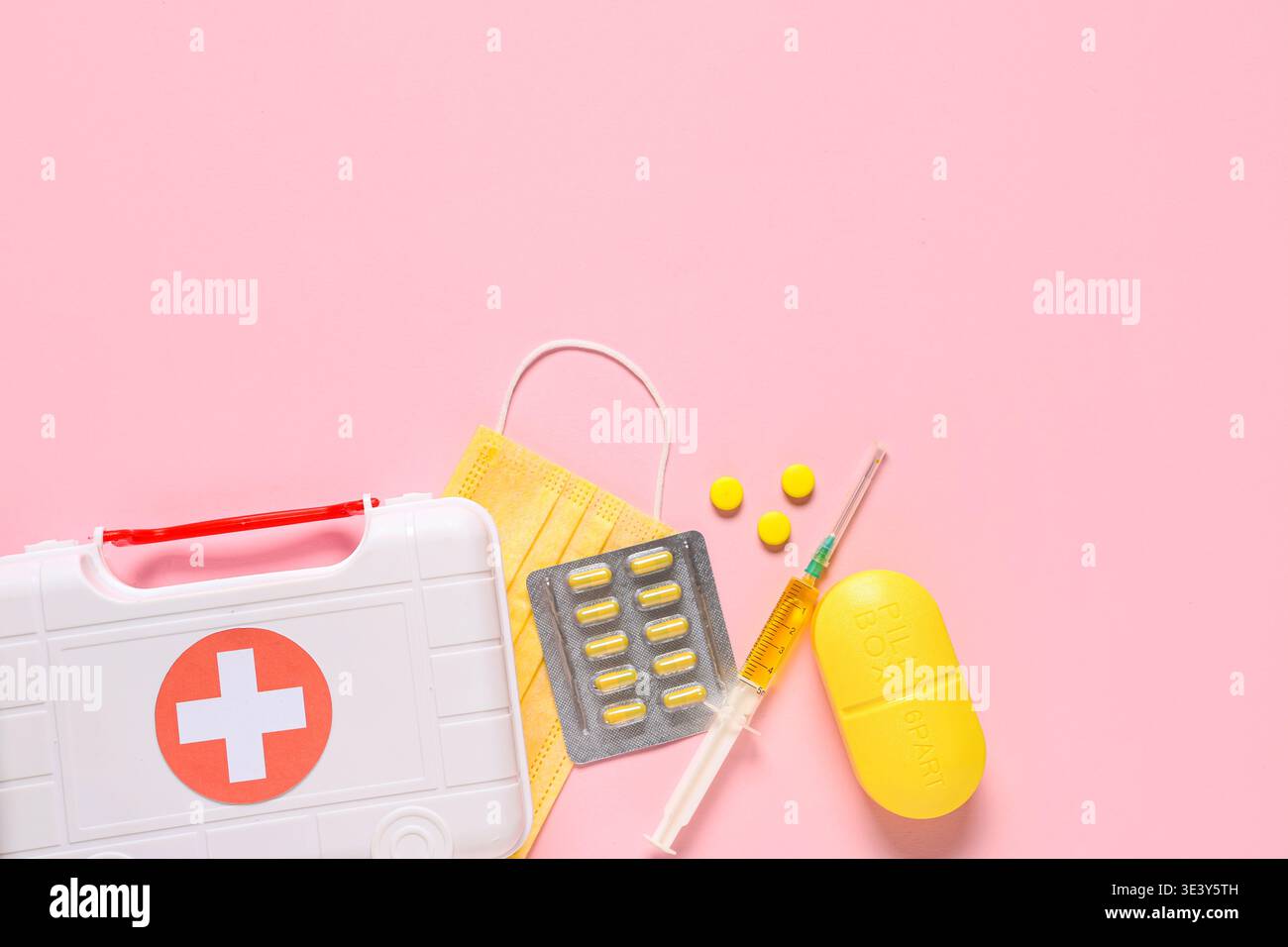 Kit di pronto soccorso con pillole, maschera medica e siringa su sfondo rosa Foto Stock