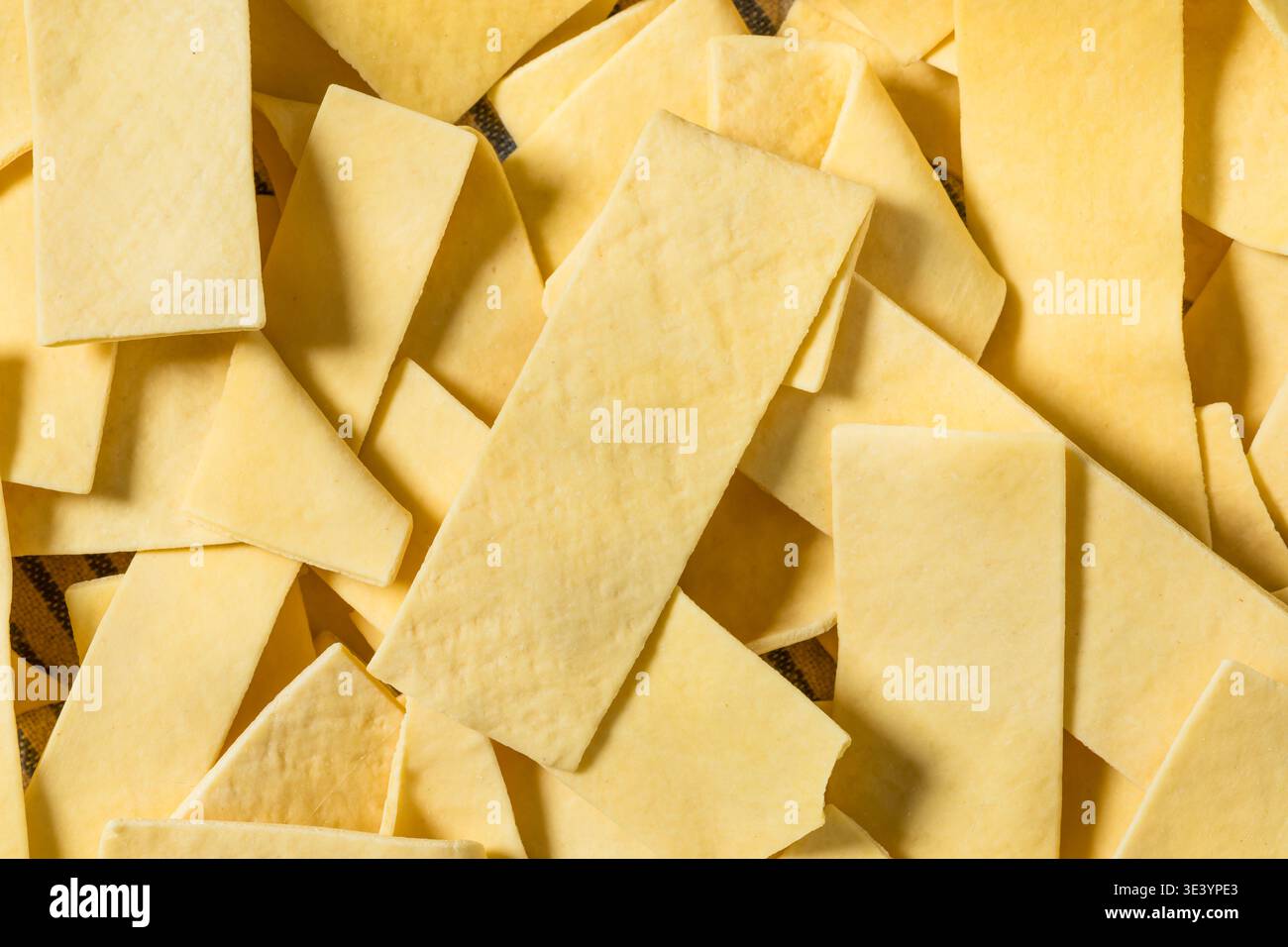 Asciugare gli spaghetti organici larghi in una ciotola per cuocere la zuppa Foto Stock