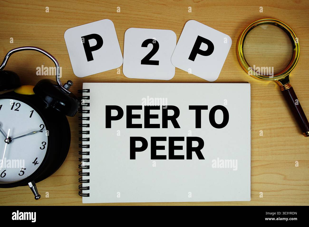 Testo P2P Peer to Peer scritto su blocco note con lente d'ingrandimento e sveglia su sfondo in legno Foto Stock