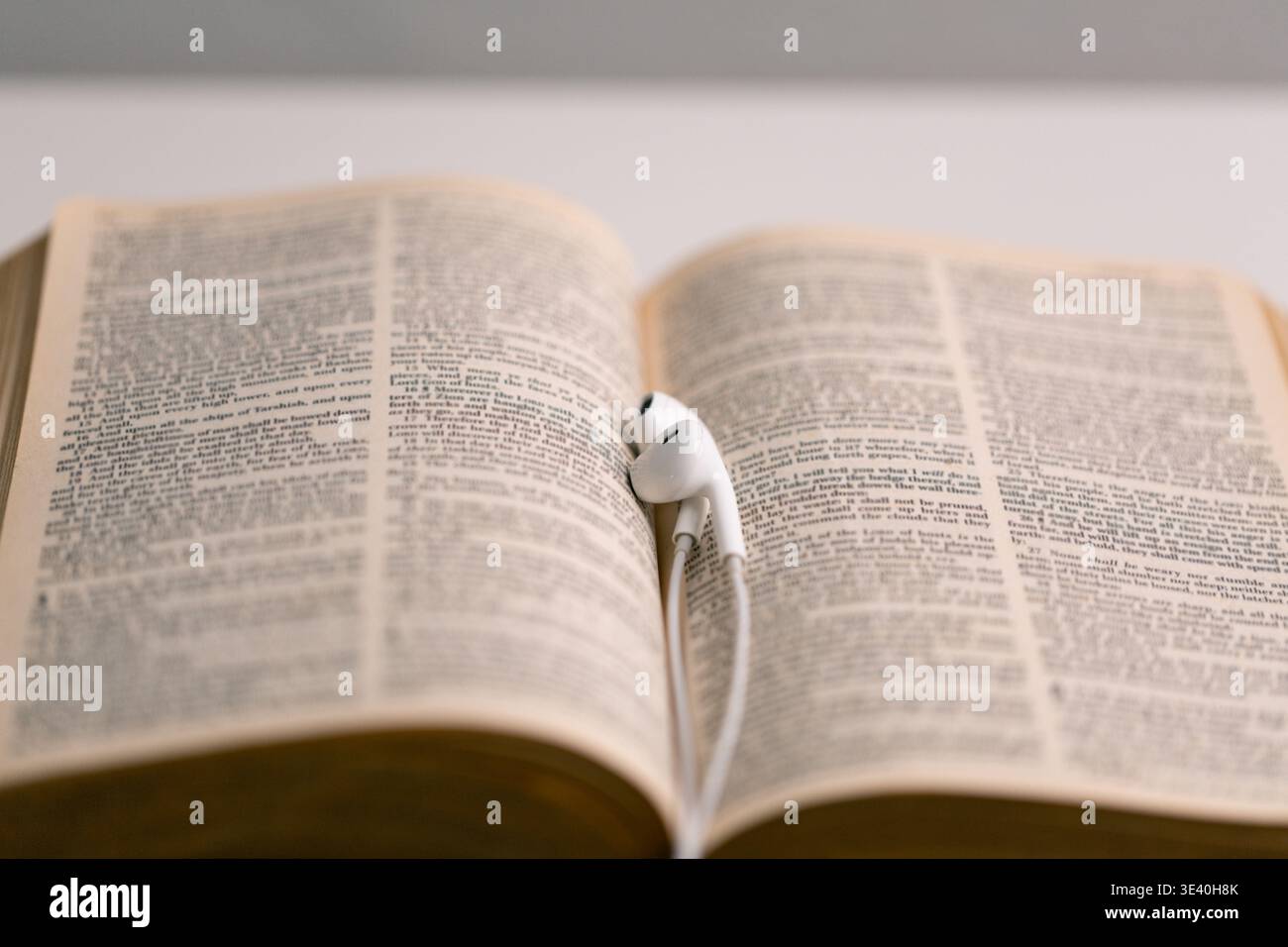 Primo piano tecnologia religiosa cuffie pregare bibbia chiesa laptop Gesù Cristo Spirito Santo servizio domenica potere spirituale sfocatura telefono di sottofondo concep Foto Stock