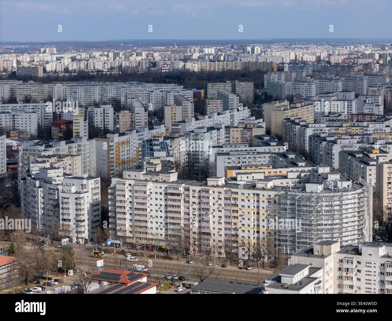 Vista aerea di edifici ad appartamenti densamente affollati che si estendono attraverso l'orizzonte sotto un cielo pallido, un arazzo di cemento intrecciato con strade, Bucarest, Bucarest Foto Stock