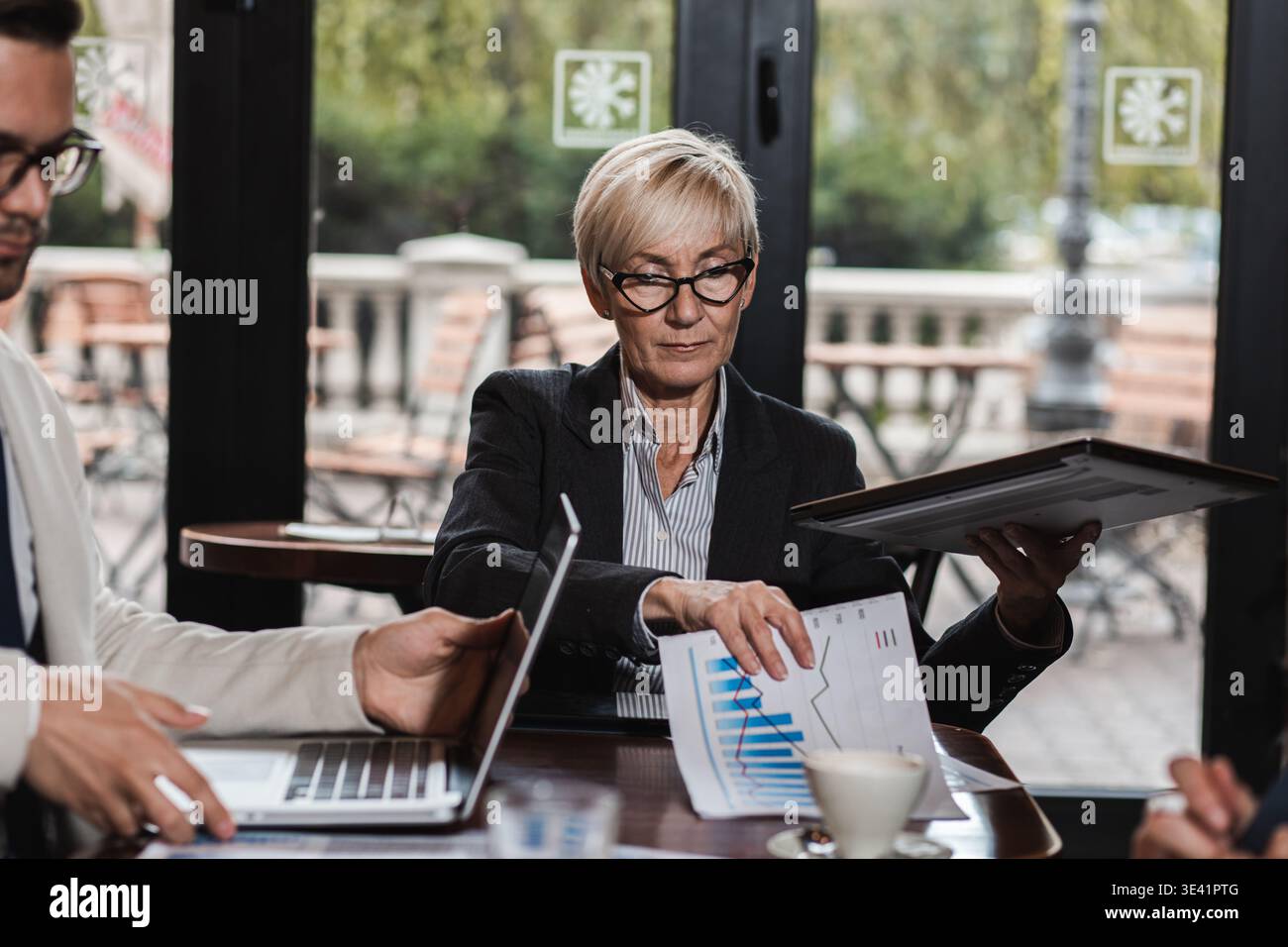 Gruppo di uomini d'affari che hanno una riunione alla caffetteria dell'ufficio. Foto Stock