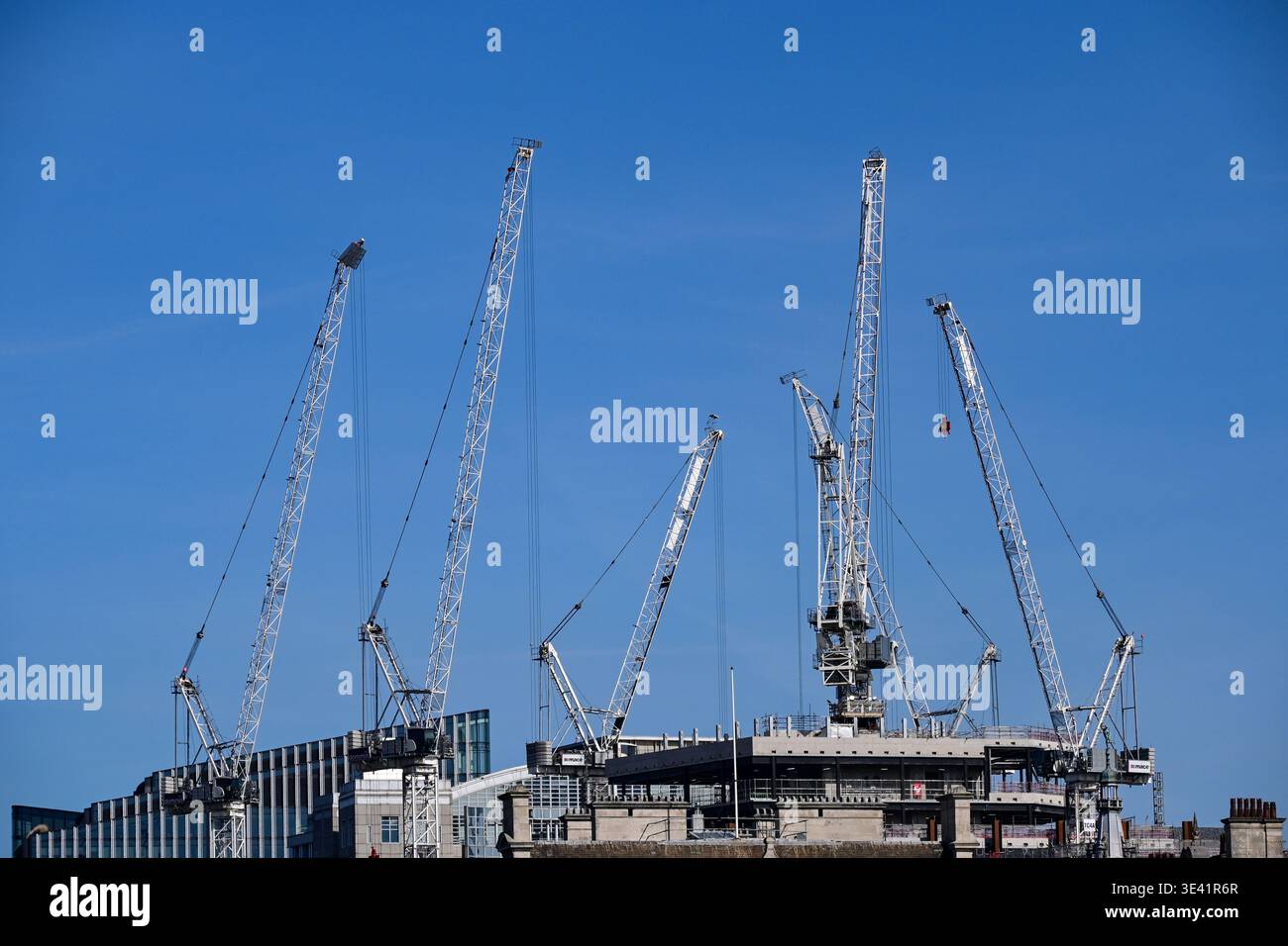 Sei gru davanti a un cielo blu sopra un cantiere nel centro di Londra, Inghilterra, Regno Unito Foto Stock