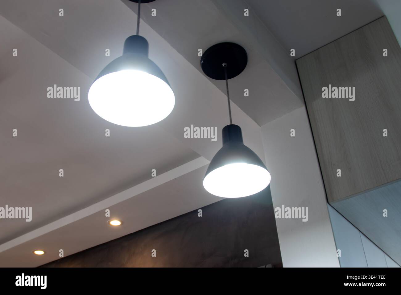 Luci a sospensione nere in un moderno ambiente interno Foto Stock