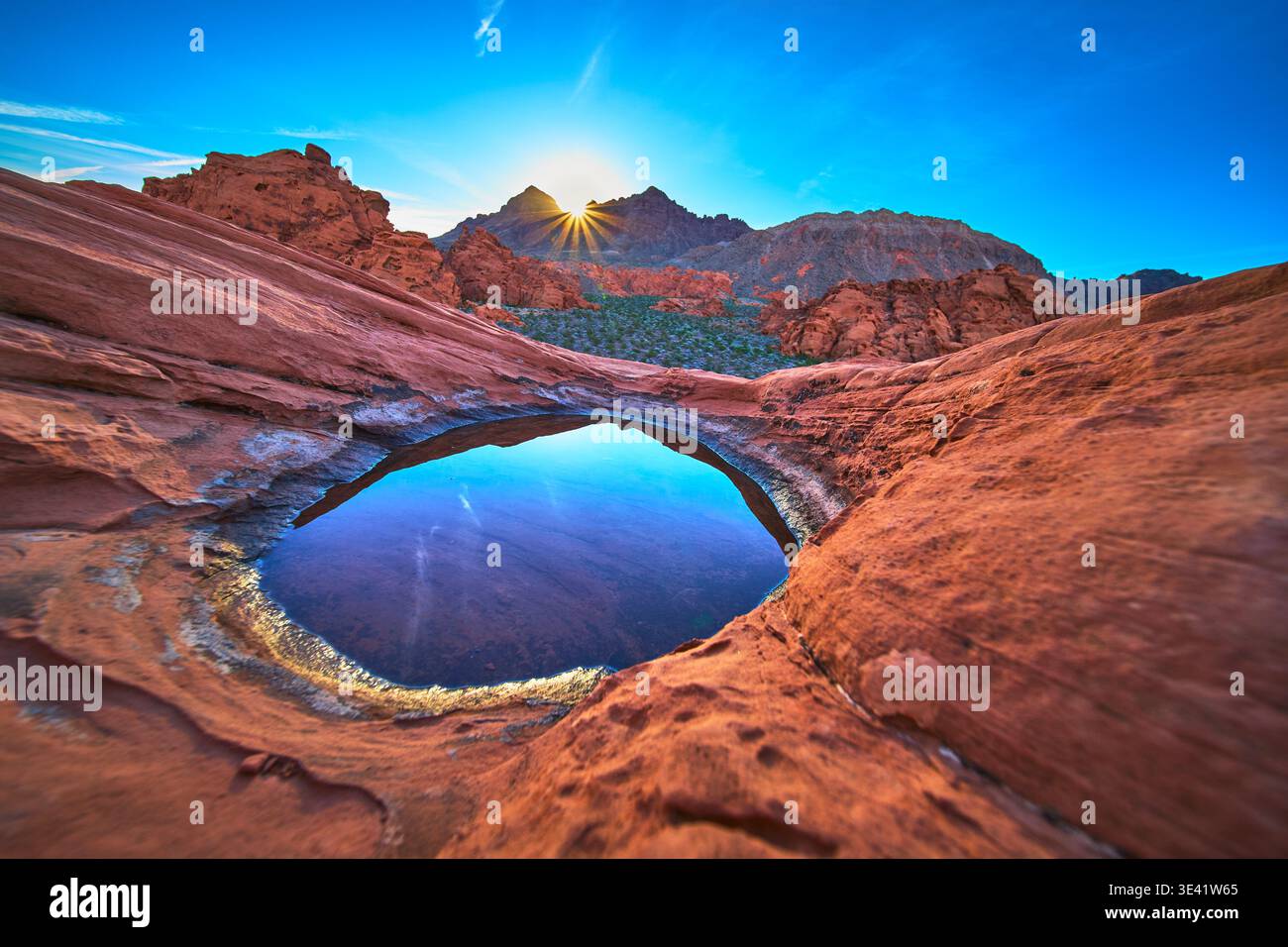 Alba sulle dune di Redstone sopra il bacino d'acqua di Tinaja nel paesaggio del deserto Foto Stock