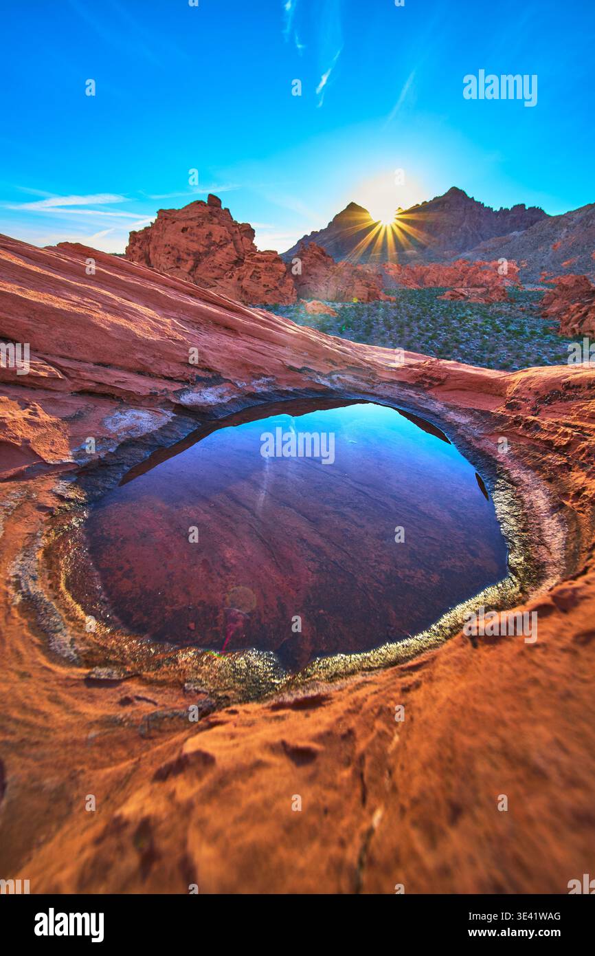 Alba sulle dune di Redstone sopra il bacino roccioso del deserto di Tinaja e la riflessione sull'acqua Foto Stock