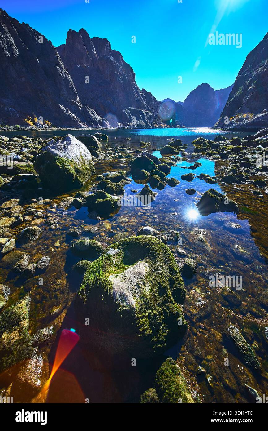 Mossy Boulders Clear Water e ripide pareti del Canyon sotto la luce del sole brillante Foto Stock