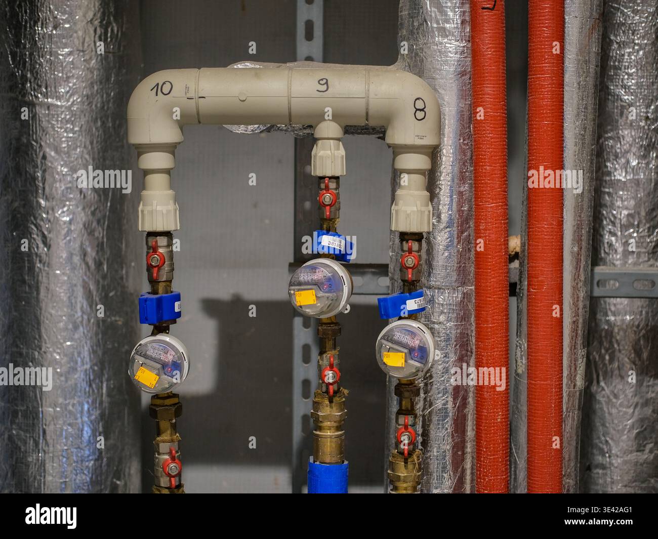 I contatori dell'acqua e le valvole sono montati su un sistema idraulico a tre linee all'interno di un'area di installazione di un edificio di pubblica utilità Foto Stock