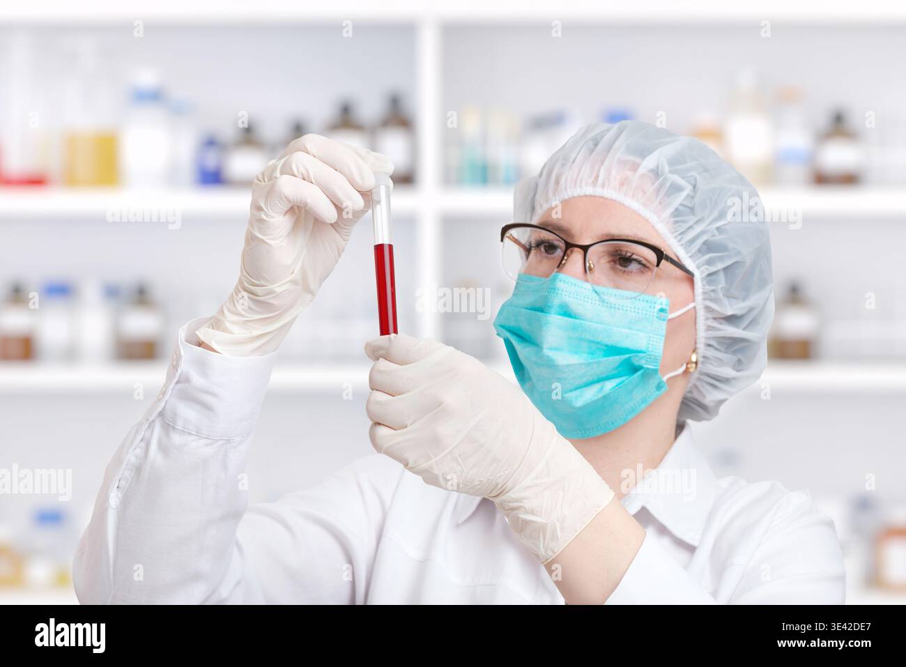 Scienziato mirato che analizza il campione di sangue in provetta, ricerca di laboratorio e concetto di diagnostica clinica in un ambiente sanitario moderno Foto Stock
