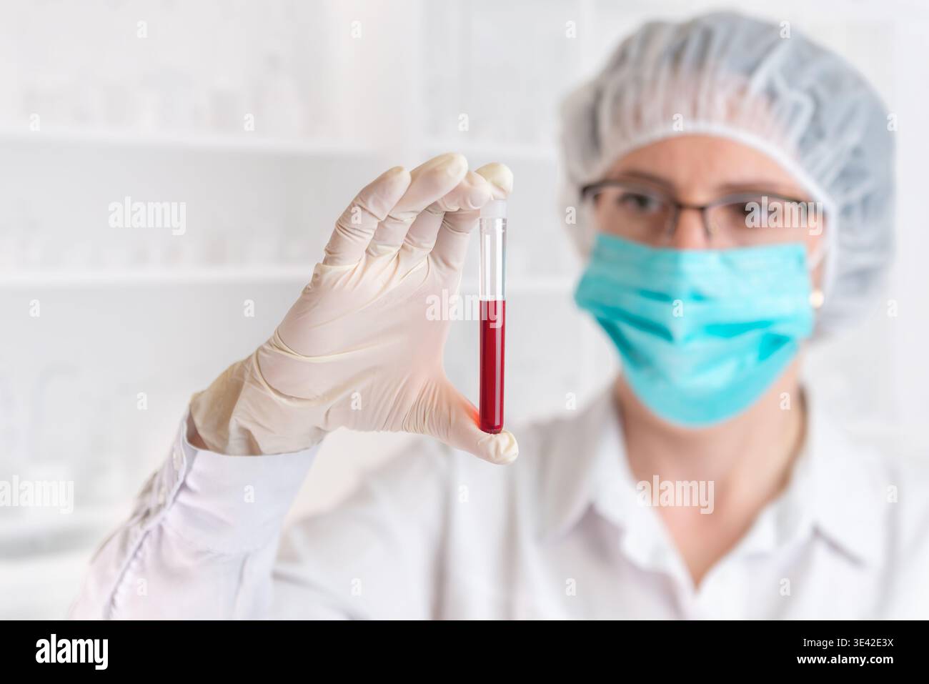 Scienziato che tiene il campione di sangue in provetta di prova, ricerca medica e concetto di test di laboratorio con medico in attrezzatura di protezione background Foto Stock