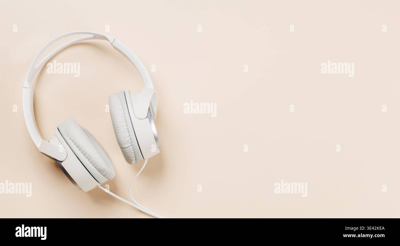 Cuffie su sfondo beige, vista dall'alto con spazio per le copie, musica moderna minimalista e concetto tecnologico Foto Stock