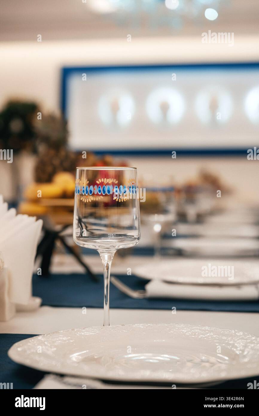 Fotografa il bicchiere di vino di marca con un raffinato sfondo per banchetti e la preparazione di un sommelier Foto Stock