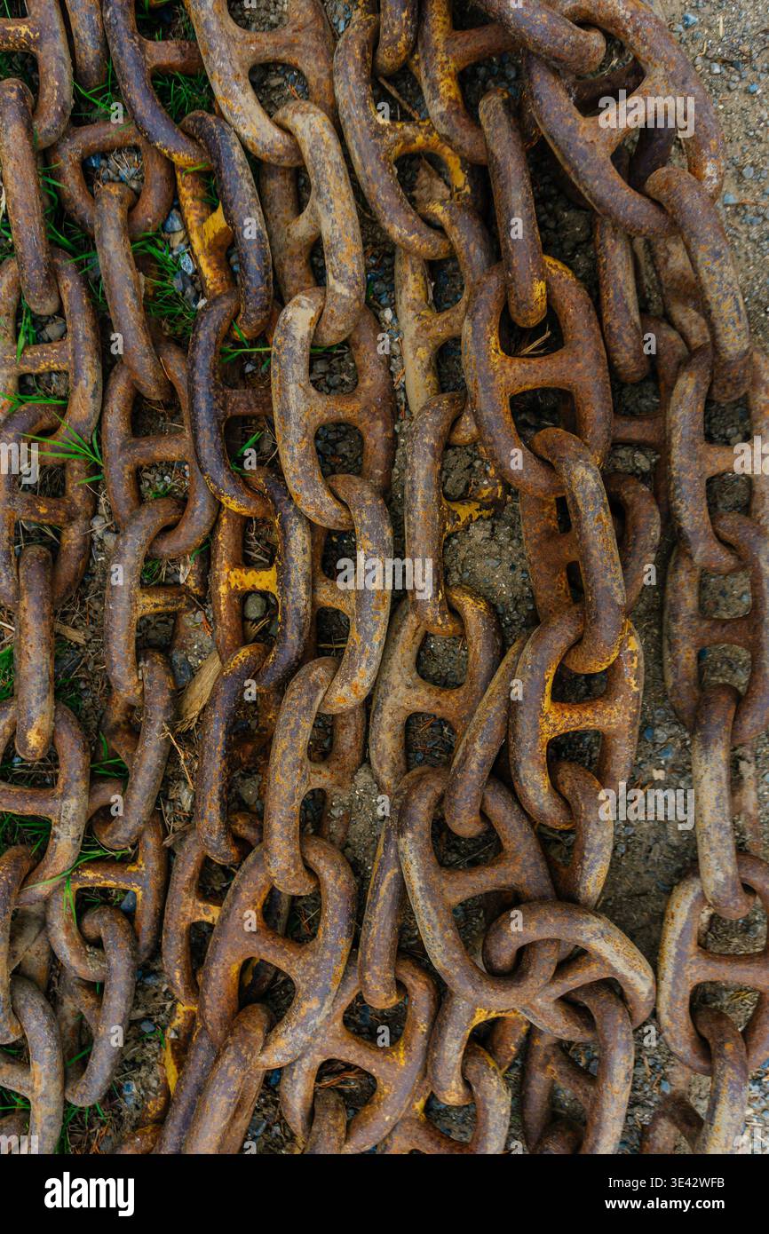 Catene arrugginite a strati che formano un modello tattile denso, ripetizione di maglie e superfici ossidate, . Foto Stock