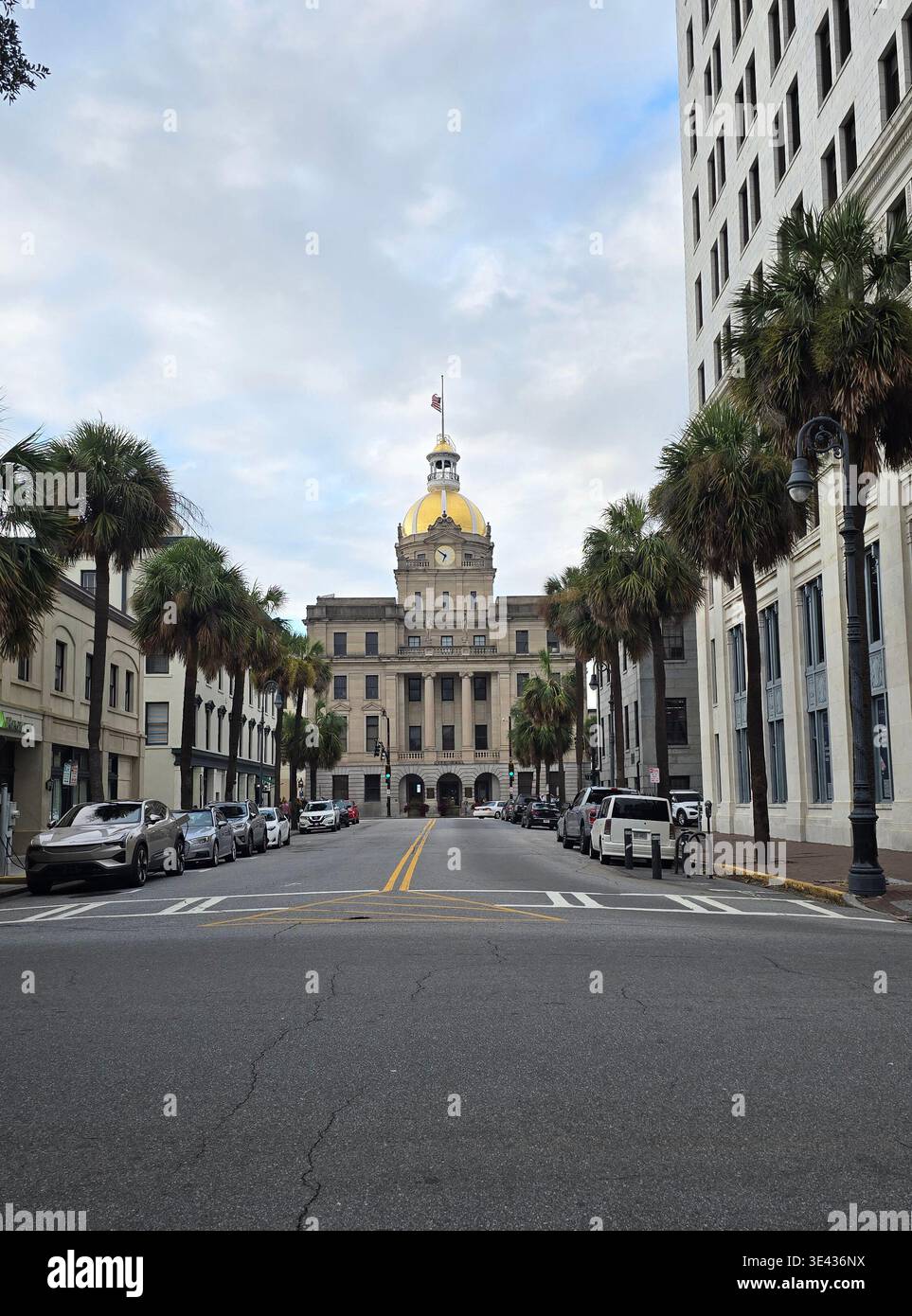 Savannah, Georgia, Stati Uniti – 30 agosto 2025: Vista sulla strada dello storico municipio di Savannah con la sua iconica cupola dorata, incorniciata da palme e dal centro città - Immagine stock catturata con smartphone