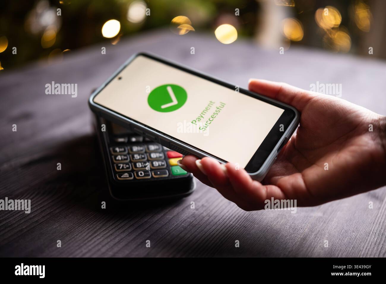 Elaborazione dei pagamenti e stato approvato sullo schermo di uno smartphone con tecnologia NFC a Natale su un tavolo Foto Stock