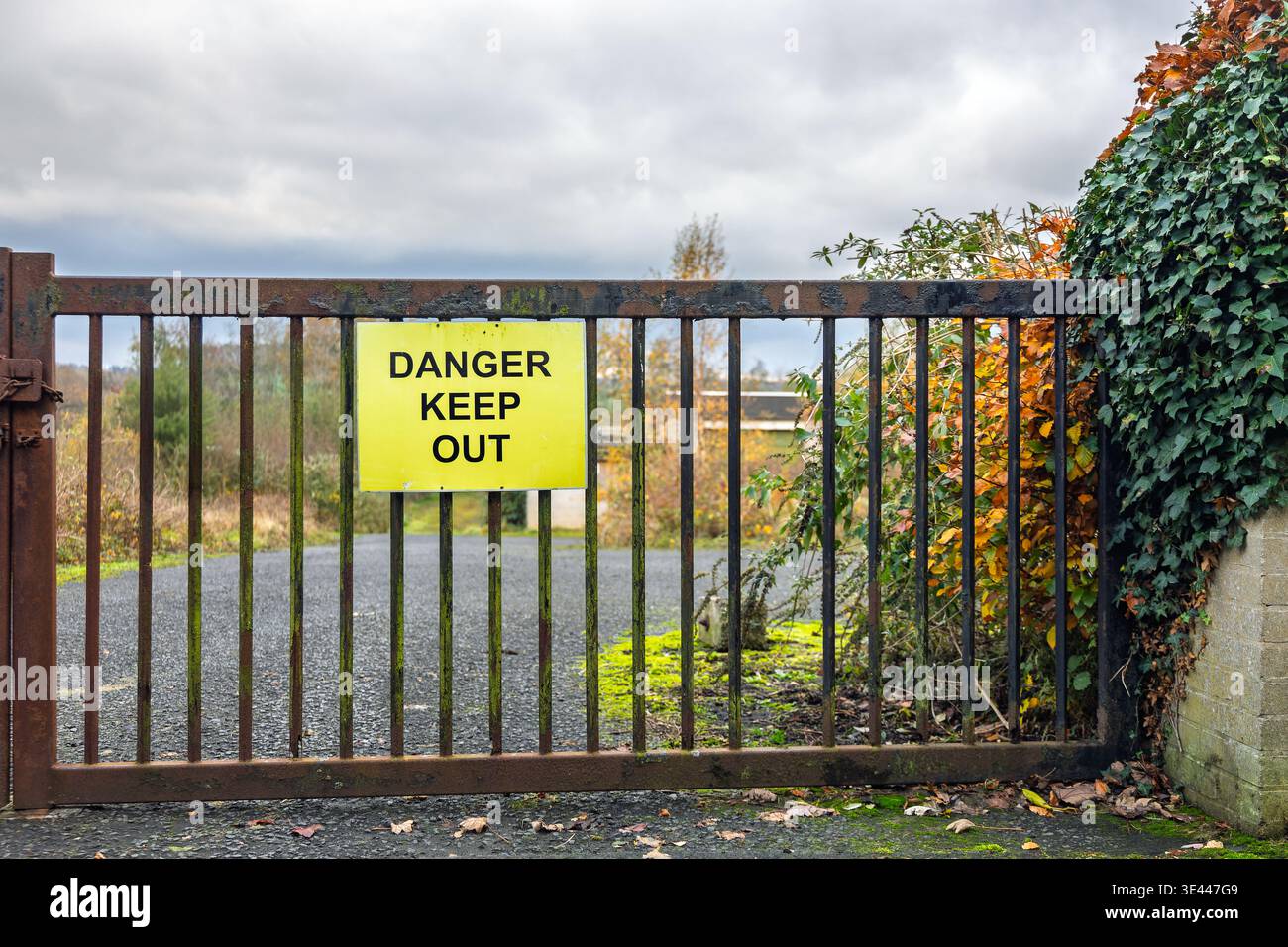 Cartello di avvertimento giallo con la scritta pericolo non attaccare a un cancello metallico arrugginito. Concetto di sicurezza, pericolo, restrizione e sicurezza Foto Stock