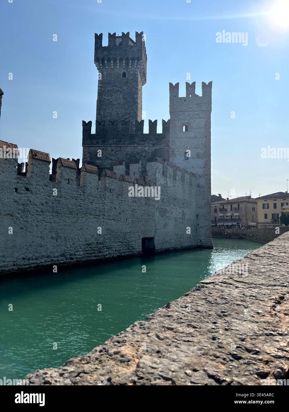 Torri del Castello Scaligero che sorgono dal fossato turchese a Sirmione sul Lago di Garda - Immagine stock catturata con smartphone