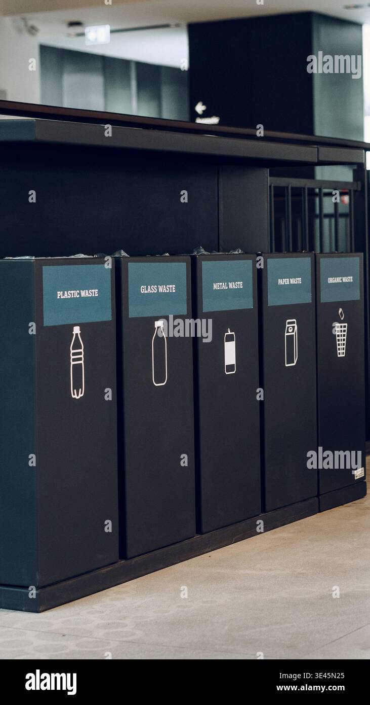 Contenitori per lo smistamento dei rifiuti presso una stazione di riciclaggio in un edificio moderno durante il giorno Foto Stock