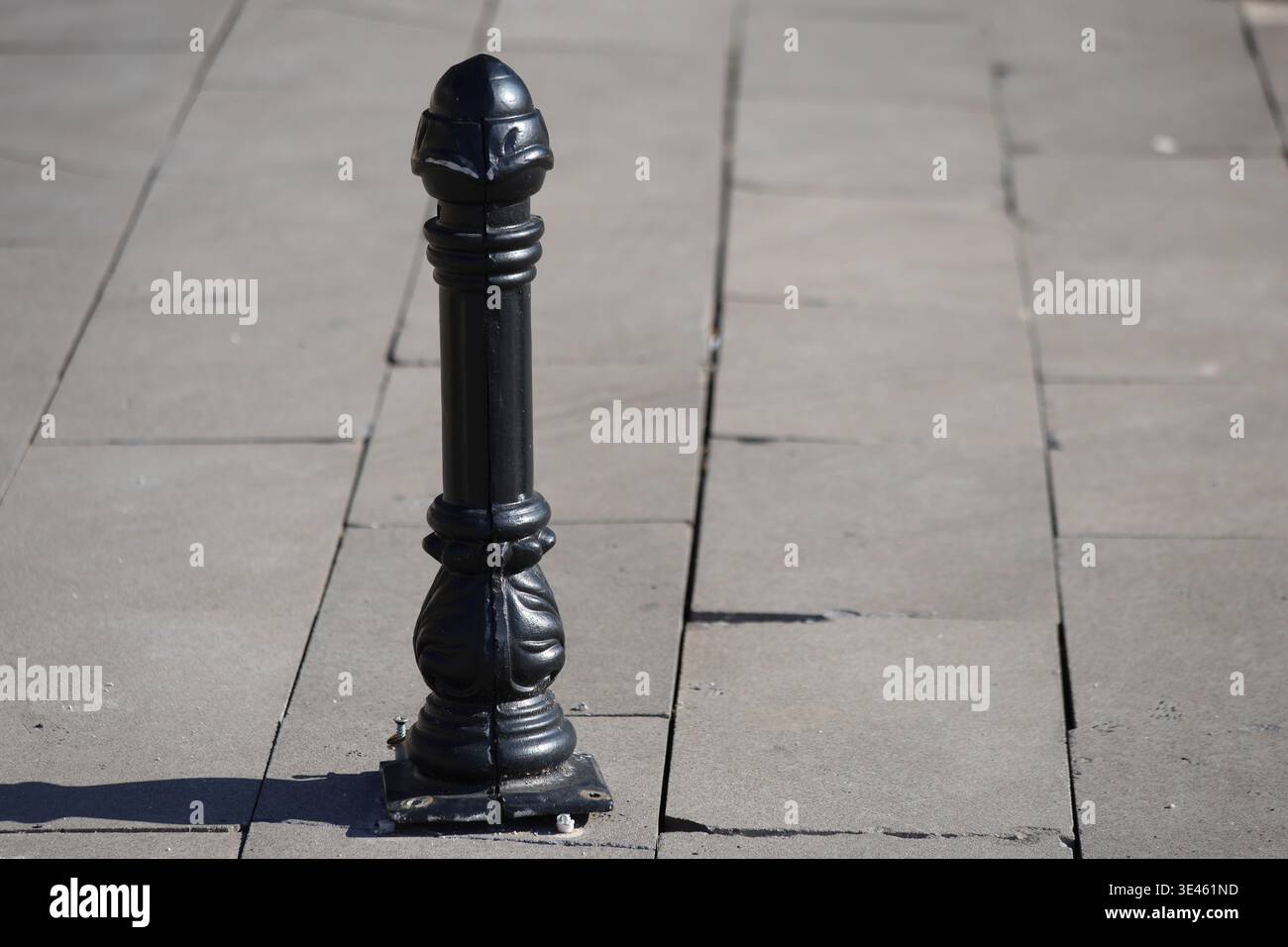 palo o in acciaio nero sul marciapiede Foto Stock