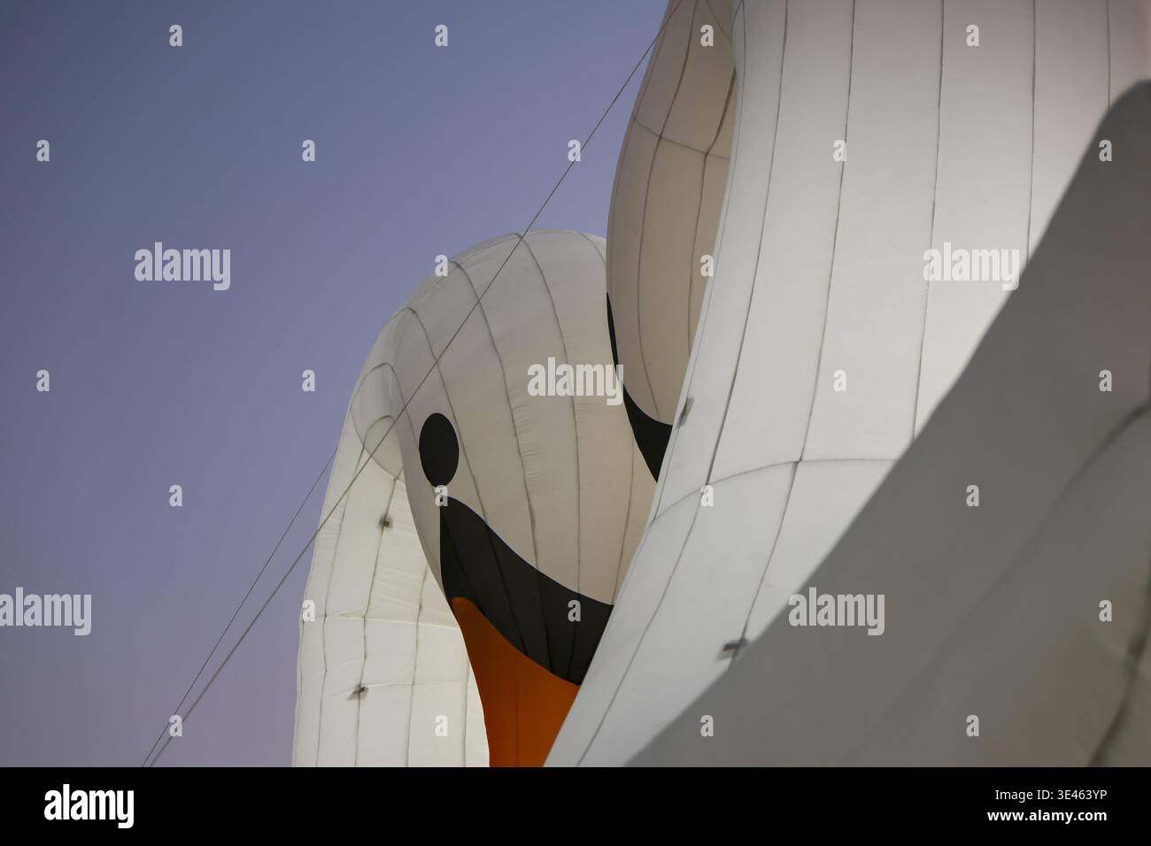 Maestosa struttura architettonica in tessuto a vela bianca che raggiunge il cielo del tramonto con forme curve e tranquille che offrono una serena sensazione estetica di calma outdoo Foto Stock