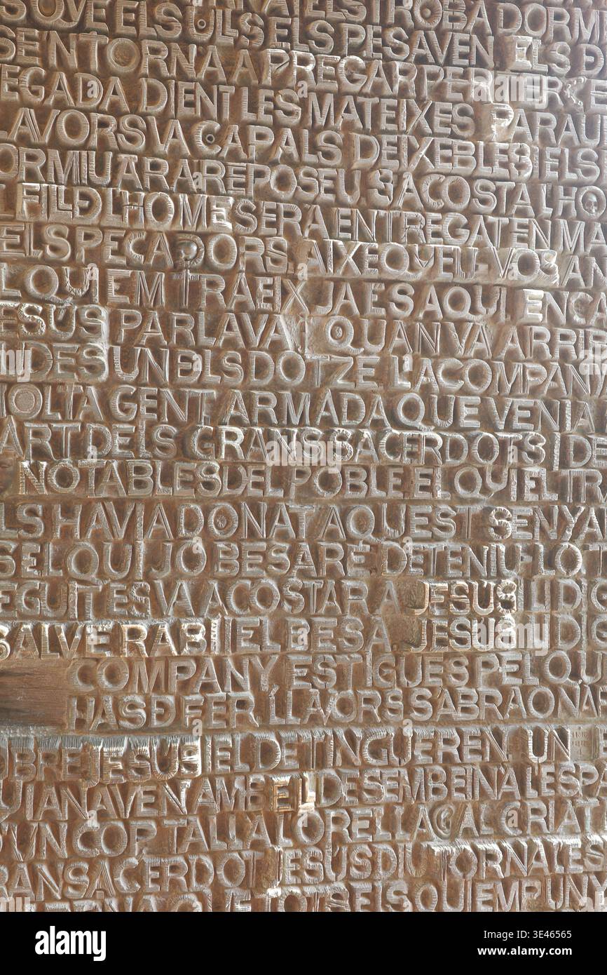 Facciata della Sagrada Família Passion, Barcellona - primo piano di testo evangelico catalano scolpito in pietra che raffigura il tradimento di Gesù da parte di Giuda. Foto Stock
