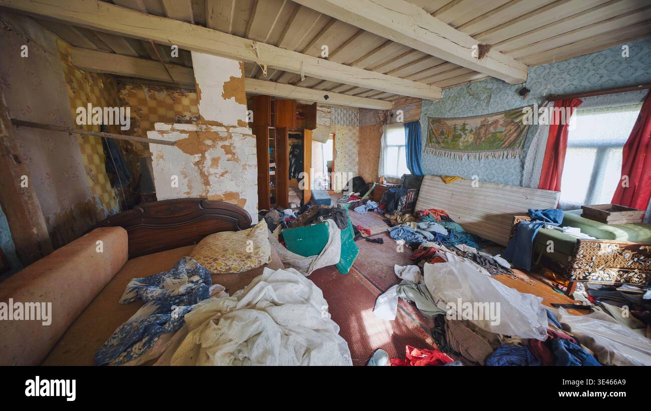 Camera abbandonata che mostrava un enorme accumulo e disordine all'interno di una vecchia casa trascurata Foto Stock