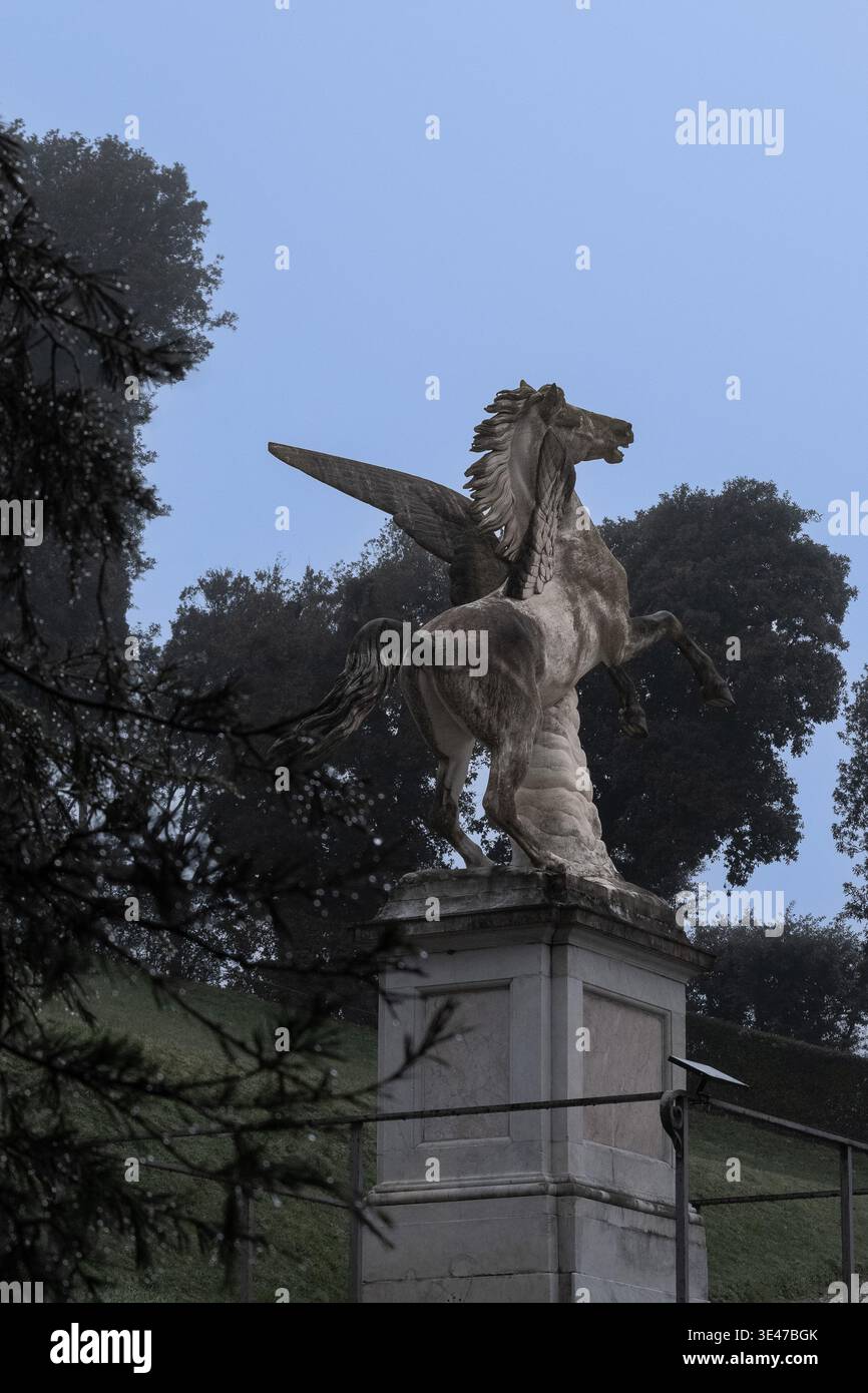 Scultura Pegasus nel giardino di Boboli con goccioline sui rami di cedro libanese Foto Stock