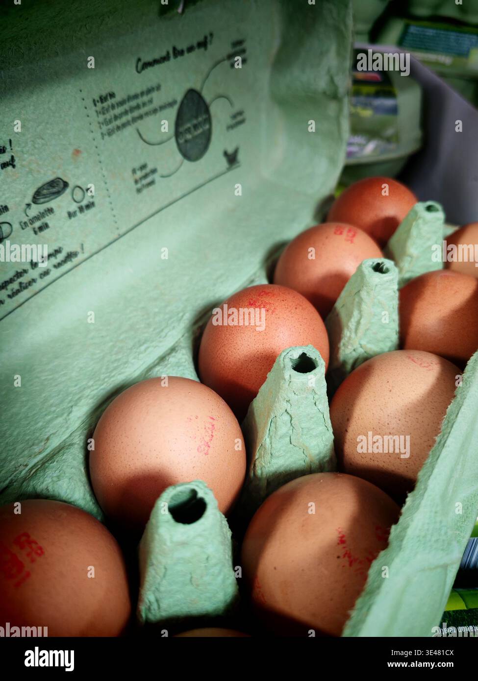 Preparare le uova scure in un vassoio rettangolare, scatola di cartone verde. Riporre in negozio. Preparazione per Pasqua Foto Stock