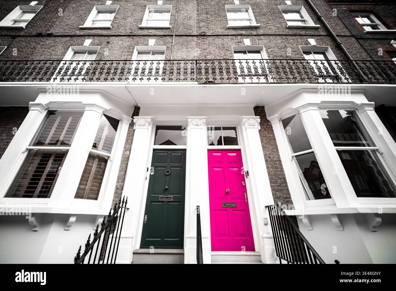LONDRA - Casa cittadina di Chelsea di colore bianco e nero selettivo con porta d'ingresso rosa vibrante Foto Stock