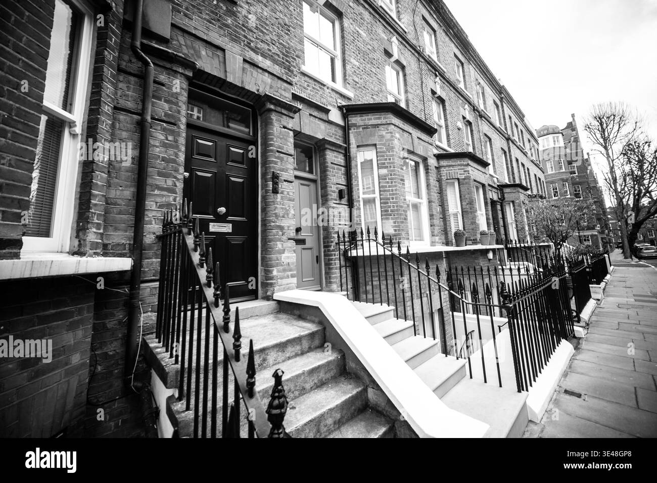 LONDRA - Case bianche e nere di Chelsea con gradini e ringhiere sulla classica strada residenziale Foto Stock