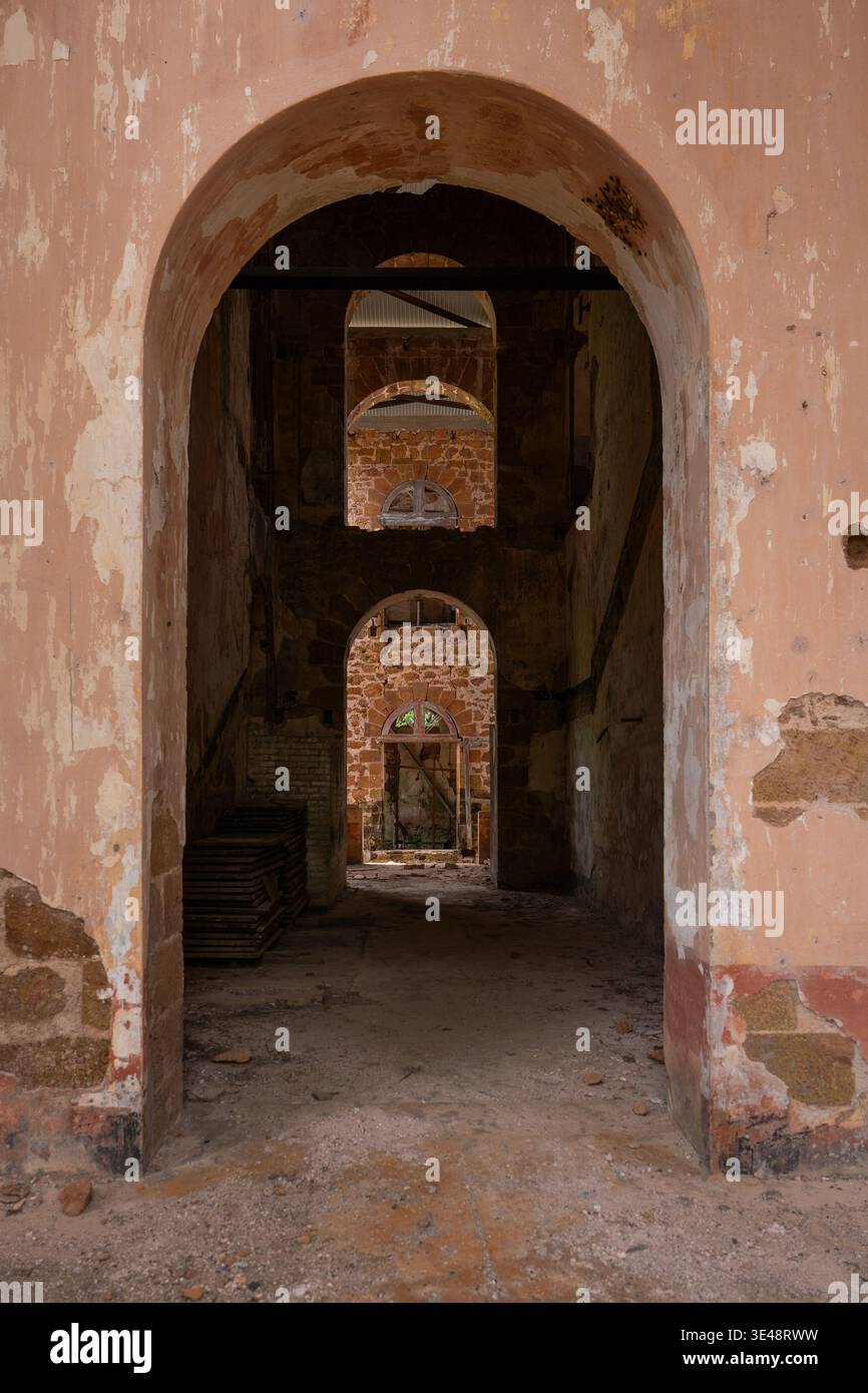 Vista dell'interno di edifici in pietra in rovina con archi multipli e pareti sbriciolate a Iles du Salut, Guyana. Foto Stock