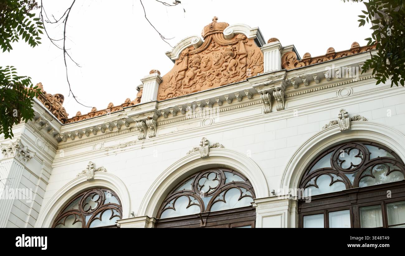 21 settembre 2025 - Bucarest, Romania: Dettagli della facciata del Palazzo Sutu con finestre in stile neogotico, stemma in terracotta e ornamento architettonico storico i Foto Stock